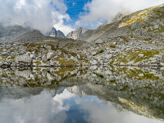 View towards Cima Presanella draped in clouds near Rifugio Segantini. Presanella mountain range,...