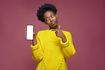 Beautiful modern young girl 20s showing phone with empty blank mock-up screen, advertising new mobile apps