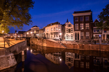 Fototapeta na wymiar Europe, The Netherlands, Schiedam. Canal and town at night.