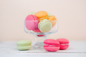 Multicolored macaroons cake in a transparent glass vase. Colorful almond cookies, pastel colors.