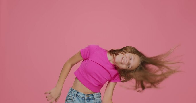 Funny energetic little girl child ruffle long blond hair, shaking head, having fun. Child's haircare cosmetics ad