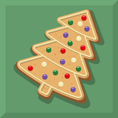 Christmas gingerbread cookies in the shape of a Christmas tree decorated with colorful balls. Gingerbread lies at an angle on a green background.