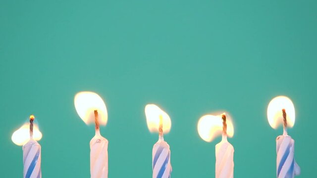 Happy Birthday concept Made of Burning Colorful Candles on blue or turquoise background. Burning 5 years anniversary birthday candles. Slow-motion full HD video