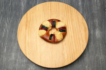 The roscón, rosca de Reyes or king cake is a sweet dough bun decorated with candied or crystallized fruit, with figurines inside for January 6, Three Kings Day.

