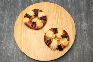 The roscón, rosca de Reyes or king cake is a sweet dough bun decorated with candied or crystallized fruit, with figurines inside for January 6, Three Kings Day.

