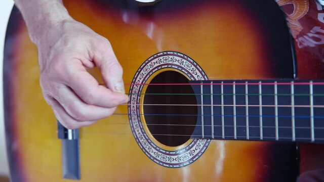 closeup male hands, middle-aged man plays acoustic guitar music, teacher teaches how to play musical instrument, blogger performance, concept of unique bard song