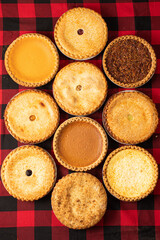 Vertical top view of a variety of mini tarts and pies © Unitymike/Wirestock