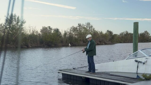 Fishing off a small dock an older adult enjoying some relaxing recreational time important for mental health.