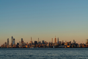 New York City skyline from New Jersey over the Hudson River with the skyscrapers of the Hudson Yards district at sunset. Manhattan, Midtown, NYC, USA. A vibrant business neighborhood