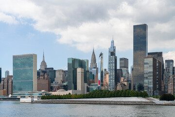 New York City skyline from Roosevelt island over the East river towards the skyscrapers of Manhattan Midtown and United Nation headquarters at day time, NYC, USA. A vibrant business neighborhood