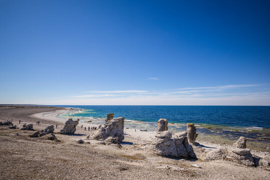 Sweden, Faro Island, Langhammars Area, Langhammar coastal limestone rauk rocks with visitors