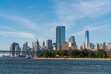 Fototapeta premium Brooklyn and Manhattan bridges with New York City financial downtown skyline panorama at day time over East River with blue cloudy sky.