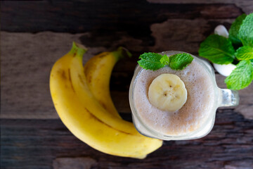 Banana fresh cocktail vanilla smoothies  fruit juice beverage healthy the taste yummy in glass drink episode good morning on wooden background from the top view.