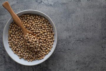 Soybean raw food nutrition in wooden spoon on a bowl
