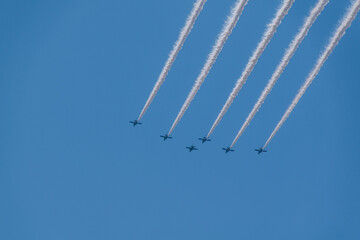 青空を飛ぶ飛行機の隊列と飛行機雲