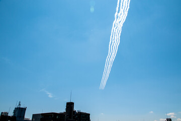 青空を飛ぶ飛行機の隊列と飛行機雲