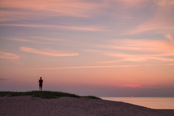 Fototapeta na wymiar Sweden, Scania, Malmo, Riberborgs Stranden beach area, woman watching sunset