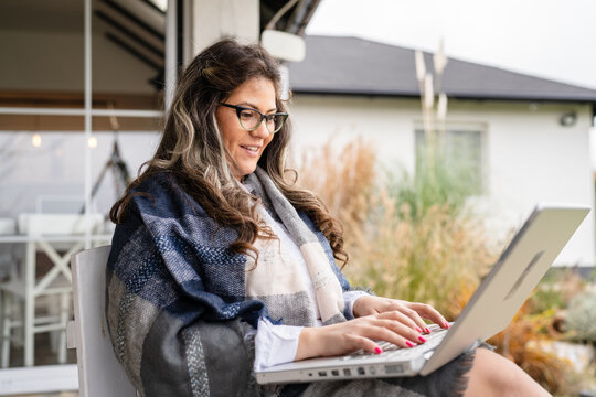 One Young Adult Caucasian Woman Sitting In Front Of Her Home In Day Holding Laptop Computer Working Or Using For Social Network While Having A Cup Of Coffee Happy Smiling Real People Copy Space