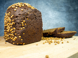 Sliced ​​brown bread sprinkled with coriander. Borodino bread. Flour product.