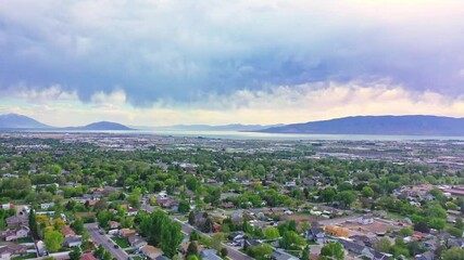 Aerial over Pleasant Grove Utah, late spring evening sunset with clouds and lake