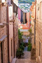 Fototapeta na wymiar Dubrovnik, Croatia. Looking down a steep and narrow passage between buildings, with laundry strung across.