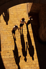 Dubrovnik, Croatia. Shadows of pedestrians cast on old stone street.