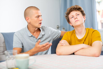 Father soothes teenager son after quarrel at home