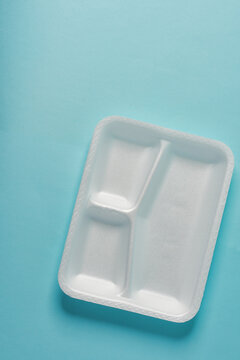 white Styrofoam plastic plates on blue background. Trash plastic, reusable plastic, disposable, for food.