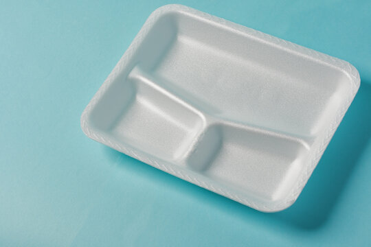 white Styrofoam plastic plates on blue background. Trash plastic, reusable plastic, disposable, for food.