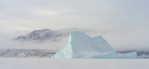 Icebergs in front of Storen Island, frozen into the sea ice of the Uummannaq fjord system during winter. Greenland, Danish Territory