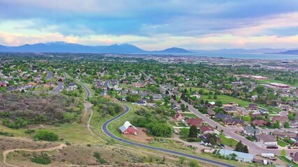 Aerial over Pleasant Grove Utah, late spring evening sunset with clouds and lake