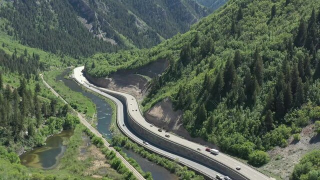 Aerial drone shot of Provo River in mountain canyon with highway in Utah summer