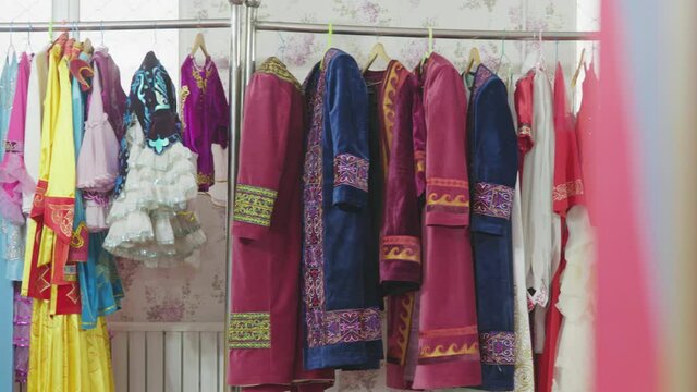 Traditional Kazakh style dresses hung neatly in a dressing room.
