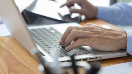 Financial or accounting professionals use  laptop and tablet to analyze the company's revenue-expenses graph to prepare for presentation to the chief executive and partner, Business data analysis.