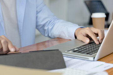 Financial or accounting professionals use  laptop and tablet to analyze the company's revenue-expenses graph to prepare for presentation to the chief executive and partner, Business data analysis.