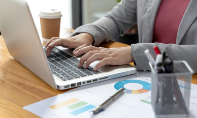 Businesswoman's hand presses on a laptop keyboard, Using computers to conduct financial transactions because the convenience and speed, World of technology and internet communication.