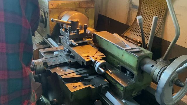 a man works on a lathe in a workshop. men's hands men's work lathe industry parts manufacturing soviet machine ussr