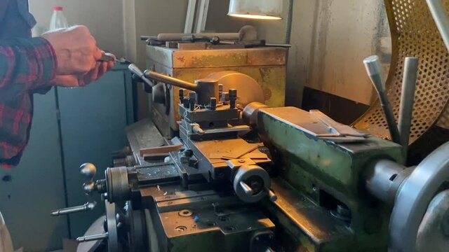 a man works on a lathe in a workshop. men's hands men's work lathe industry parts manufacturing soviet machine ussr