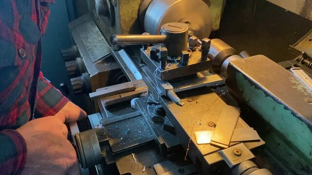 a man works on a lathe in a workshop. men's hands men's work lathe industry parts manufacturing soviet machine ussr