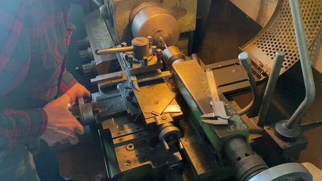 a man works on a lathe in a workshop. men's hands men's work lathe industry parts manufacturing soviet machine ussr