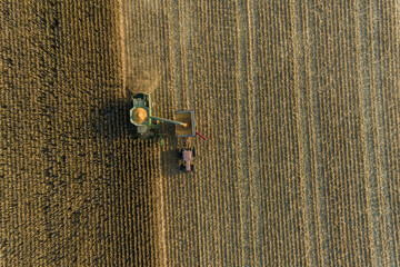 Aerial view of combine harvesting corn and unloading into auger wagon, Marion County, Illinois