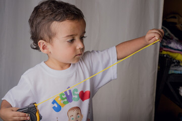 portrait of a little boy using a tape measure