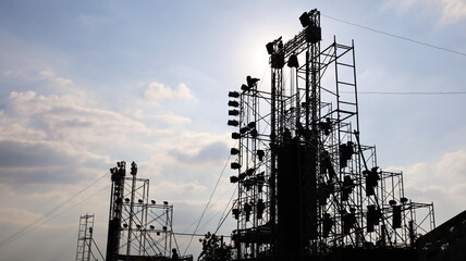 Stage structure silhouette. Concert stage with outdoor lighting and sound equipment on cloudy sky...