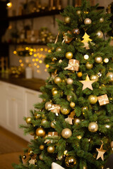 beautiful Christmas tree with golden balls. Happy among New Year's decor. 