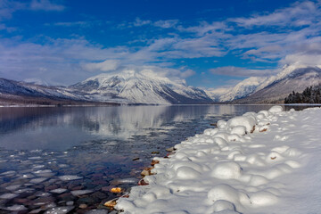 Mountains reflect in wintry Lake McDonald in Glacier National Park, Montana, USA