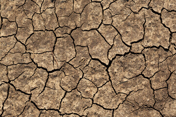 Texture of cracked dried soil. Dry ground with cracks. Brown rough surface of the soil during...