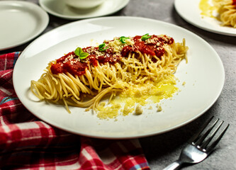Delicious classic homemade spaghetti al pomodoro with a beautiful summer tomatoes. Served with parmesan cheese and fresh basil. Presented with copy space, top view.
