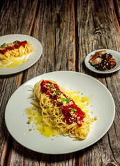 Delicious classic homemade spaghetti al pomodoro with a beautiful summer tomatoes. Served with parmesan cheese and fresh basil. Presented with copy space, top view.