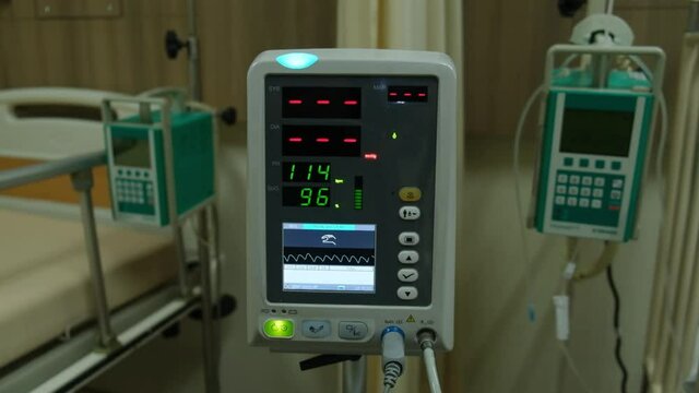 Low light footage with noise effect added of vital sign monitor used in a hospital.