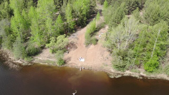 Aerial view of the bank of a quarry and floating people (Strizhi, Kirov region, Russia)